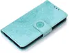 A teal flip case for a smartphone with a mandala pattern embossed on the cover. Produktbild-Vorschau