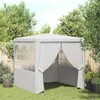A white party tent with side walls is set up on a green lawn in a backyard setting.
