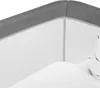 A close-up view of the edge of a crib or bassinet, showing the gray fabric trim and white mesh side. Produktbild-Vorschau