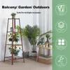 A plant stand with plants on it, next to a table with more plants and a basket. Produktbild-Vorschau