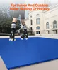 A person wearing roller skates stands on a blue interlocking floor tile surface in front of a building. Podgląd zdjęcia produktu