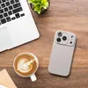 A top-down view of a desk setup with a laptop, a cup of coffee with latte art, and a smartphone case. Produktbild-Vorschau