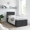A single bed with a dark gray upholstered base and headboard is shown in a bright room. Produktbild-Vorschau