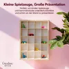 A wooden display shelf with small toys and collectibles is shown against a pink and white background with a plant in the foreground. Produktbild-Vorschau