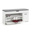 A white shoe cabinet with a gray upholstered seat on top, filled with various shoes. Produktbild-Vorschau