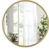 A round mirror with a golden frame is shown against a white background. The mirror reflects a doorway with white curtains and a potted plant. Produktbild-Vorschau
