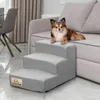 A small dog is lying on a couch next to a set of pet stairs. Podgląd zdjęcia produktu
