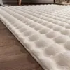A close-up view of a cream-colored, textured rug on a wooden floor. Produktbild-Vorschau