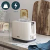 A beige toaster on a kitchen counter with toast popping out. Anteprima dell’immagine prodotto