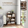A 3-tier bookcase with items on its shelves, placed next to a sofa and in front of a window with curtains. Produktbild-Vorschau