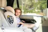 A young child sits in a car seat in a car. Voir les images du produit
