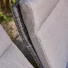 A close-up view of the side of a sofa, showing the woven material and fabric cushion. Produktbild-Vorschau