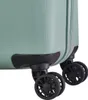 A close-up view of the bottom corner of a light green suitcase, showing its black wheels and protective casing. Náhľad obrázku produktu