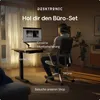 A person is working at a standing desk in a modern home office setting. Produktbild-Vorschau