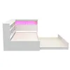 A white daybed with a pull-out trundle bed and integrated shelving unit, featuring pink LED lighting in the headboard. Produktbild-Vorschau