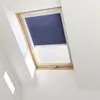 A dark blue roller blind is partially covering a skylight window with a wooden frame. Produktbild-Vorschau