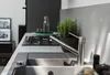 A modern kitchen sink area with a faucet, stovetop, and a potted plant. Anteprima dell’immagine prodotto