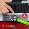 A close-up of a person's hand adjusting the temperature dial on a waffle maker, with marketing text overlays highlighting features. Produktbild-Vorschau
