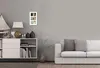 A living room scene with a white cabinet, a lamp, vases, books, a framed photo collage, and a white sofa. Náhled obrázku produktu