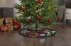 A Christmas tree with ornaments and lights, with a toy train set around the base. Podgląd zdjęcia produktu