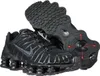 A pair of black Nike Shox TL sneakers are displayed against a white background. One shoe is shown from the side, while the other is shown from the sole, revealing its unique cushioning system and red accents. Produktbild-Vorschau