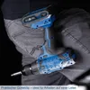 A person wearing jeans and a black shirt is shown with a cordless drill attached to their belt. Voir les images du produit