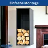 A black metal firewood rack filled with logs is mounted on a wall next to a fireplace. Produktbild-Vorschau