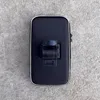 A black bicycle phone holder is placed on a concrete surface. Voir les images du produit