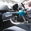 A person is using a Makita leaf blower inside a car. Produktbild-Vorschau