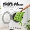 A hand is placing a green seat cushion into an open washing machine. Produktbild-Vorschau