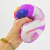 A hand squeezing a colorful anti-stress ball. Produktbild-Vorschau