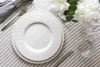A table setting with plates, cutlery, a napkin, and flowers. Náhled obrázku produktu