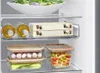 Inside a refrigerator, showing food items stored in containers and bottles on shelves. Produktbild-Vorschau