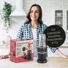 A woman is standing in a kitchen with a nutrition mixer and its packaging on the counter. Podgląd zdjęcia produktu
