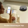 A woman is using a smartphone to control a robot vacuum cleaner in a living room. Anteprima dell’immagine prodotto