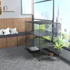 A multi-level pet enclosure is set up indoors near a large window, with a bench and pillows to the left. Podgląd zdjęcia produktu