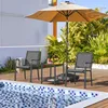 Two chairs and a small table are set up next to a swimming pool under a patio umbrella. Produktbild-Vorschau