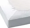 A close-up view of a white fitted sheet on a mattress. Produktbild-Vorschau