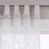 A close-up view of white sheer curtains with a branch pattern hanging from a curtain rod. Produktbild-Vorschau