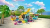 A LEGO Friends pool party playset with slides, figures, and accessories, set against a tropical backdrop with palm trees and the ocean. Produktbild-Vorschau
