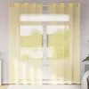 A window with yellow sheer curtains covering it, with a radiator visible underneath. Voir les images du produit