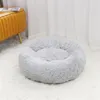 A round, fluffy gray pet bed sits on a white rug in front of sheer white curtains. A portion of a yellow ottoman is visible to the left. Anteprima dell’immagine prodotto