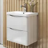 A white bathroom vanity with two drawers and a chrome faucet is mounted on a slatted wooden wall. Produktbild-Vorschau