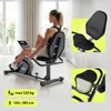 A woman is using a recumbent exercise bike in a bright, modern living room. Produktbild-Vorschau