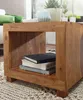 A wooden side table with books on it, in a living room setting. Produktbild-Vorschau