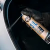 A gloved hand sprays a product onto a car's rubber seal. Produktbild-Vorschau