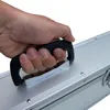 A hand is holding the handle of a silver aluminum case. Produktbild-Vorschau