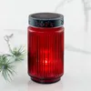 A red LED solar grablicht (grave light) with a decorative black lid sits on a marble-like surface, with a sprig of greenery to the left. Produktbild-Vorschau
