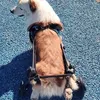 A dog in a wheelchair on a blue gravel surface. Produktbild-Vorschau
