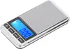 A digital pocket scale with a silver body and a blue LCD screen displaying zeros. Voir les images du produit